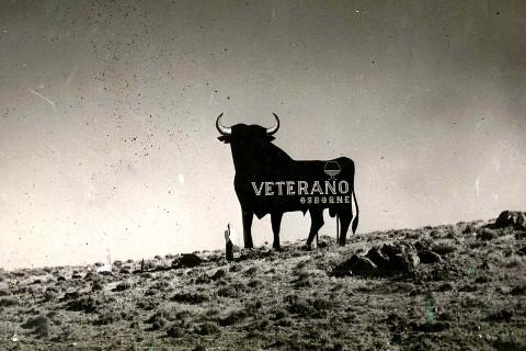 Foto en sepia del primer toro que se colocó en 1957 en Cabanillas de La Sierra, Madrid. Junto a nuestra valla publicitaria del Toro de Osborne aparece, Rafael Osborne McPherson